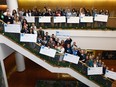 Represenatives from 12 charities with staff hold up their cheques distributed at the Calgary Herlad building from this years $967,740.00 raised from the Calgary Herald Christmas Fund on Wednesday February 7, 2018. Darren Makowichuk/Postmedia