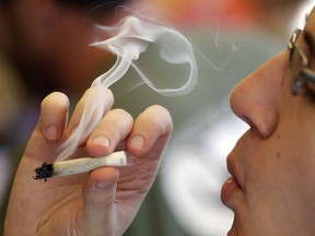 A man smokes a marijuana joint at a party celebrating weed Wednesday, April 20, 2016, in Seattle. Stamping out the illicit market is one of Ottawa's major goals as the country approaches a July 2018 deadline for the legalization of recreational marijuana ??? leaving politicians little time to lay out exactly how to sell, price and tax cannabis. THE CANADIAN PRESS/AP/Elaine Thompson