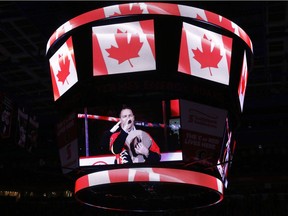 George Canyon is seen on the Saddledome scoreboard singing the national anthem earlier this month. Readers oppose a suggestion to remove reference to God from O Canada''s lyrics.