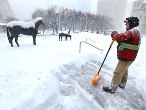 Gabor Dudar, pauses as he works to keep a priority pedestrian path clear in front of City Hall in downtown Calgary on Thursday, February 8, 2018. He works for Year Round Landscaping and says, so far, the snow is about the same as last year. Jim Wells/Postmedia
