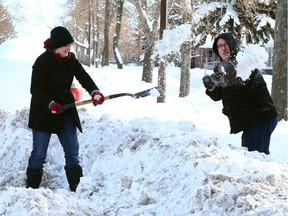 Bonnie and Neal Sanch try to access the sidewalk leading to their house earlier this month.  Reader says it's worth paying for timely removal of snow.