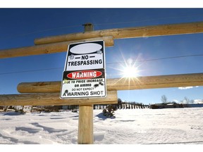 A warning sign is posted on a fence at the entrance to a rural property north of Okotoks, Alberta, south of Calgary on Tuesday, February 27, 2018. Jim Wells/Postmedia