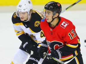 Calgary Flames Johnny Gaudreau fights for position against Danton Heinen of the Boston Bruins during NHL hockey at the Scotiabank Saddledome in Calgary on Monday, February 19, 2018. Al Charest/Postmedia
