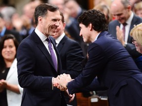 Finance Minister Bill Morneau shakes hands with Prime Minister Justin Trudeau as he arrives in the House of Commons prior to tabling the federal budget in Ottawa on Tuesday, Feb.27, 2017.
