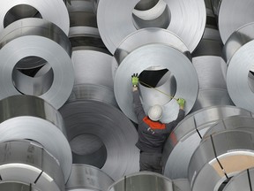 A worker measuring flat-rolled steel at Germany's second-largest steel firm Salzgitter in Salzgitter, northern Germany.