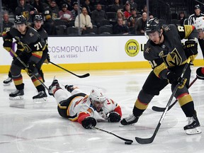 Flames Mark Giordano dives for the puck as Jonathan Marchessault of the Vegas Golden Knights drives the net during Wednesday's game in Las Vegas.