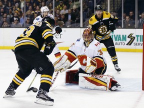 Boston Bruins' Brad Marchand (63) tries to get a shot off on Calgary Flames' David Rittich (33), of the Czech Republic, during the second period of an NHL hockey game in Boston, Tuesday, Feb. 13, 2018. (AP Photo/Michael Dwyer) ORG XMIT: MAMD111