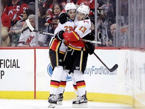 Calgary Flames left-winger Johnny Gaudreau (13) celebrates his goal against the New Jersey Devils with teammate Sean Monahan (23) during the second period of an NHL hockey game, Thursday, Feb. 8, 2018, in Newark, N.J.