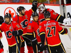 Calgary Flames goaltender Jon Gillies celebrates with teammates after a 5-1 victory over the Colorado Avalanche during NHL hockey at the Scotiabank Saddledome in Calgary on Saturday, February 24, 2018.