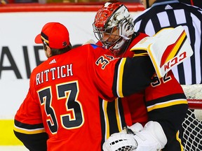 Flames goalie Jon Gillies (right) is congratulated by teammate David Rittich following a home-side win at the Saddledome on Saturday, Feb. 24, 2018.