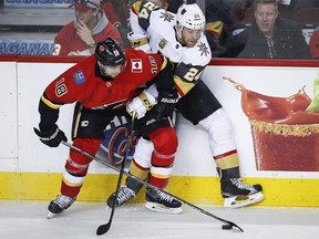 Vegas Golden Knights' Oscar Lindberg, right, of Sweden, is checked by Calgary Flames' Matt Stajan during third period NHL hockey action in Calgary, Tuesday, Jan. 30, 2018.THE CANADIAN PRESS/Jeff McIntosh ORG XMIT: JMC111