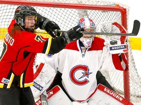 Calgary Inferno star Brittany Esposiito tips the puck on Les Canadiennes De Montreal goalie, Emerance Maschmeyer in first-period action at Winsport in Calgary, Alta., on Sunday, January 7, 2018.