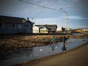 Indigenous children play in the water filled ditches in the northern Ontario First Nations reserve in Attawapiskat, Ont., on Tuesday, April 19, 2016. Indigenous Services Canada has set up a new call centre to help First Nations children get services and supports under the child-first jurisdictional policy known as Jordan's Principle. THE CANADIAN PRESS/Nathan Denette ORG XMIT: CPT139