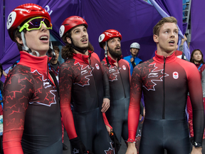 Canada's Charle Cournoyer, Samuel Girard, Charles Hamelin and Pascal Dion, left to right, look up at the replay in the men's 5000-metre short-track speedskating relay.