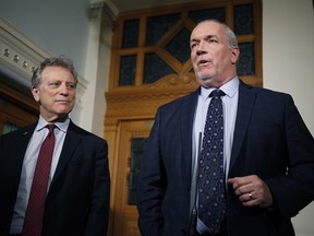 B.C. Premier John Horgan and Minister of Environment and Climate Change Strategy George Heyman answer questions about the Alberta dispute during a press conference at the Legislature in Victoria, B.C., on Feb. 7, 2018.