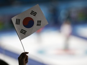 A South Korean fan waves a flag during a women's curling match against Great Britain at the Pyeongchang Olympics on Feb. 17.