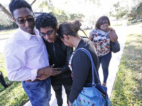 Family members embrace after a student walked out from Marjory Stoneman Douglas High School, Wednesday, Feb. 14, 2018, in Parkland, Fla. The shooting at the South Florida high school sent students rushing into the streets as SWAT team members swarmed in.