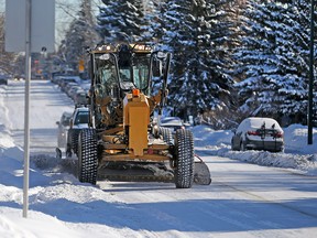 A City of Calgary grader clears snow along the 20th Avenue N.W. after a snow route parking ban came into effect on Monday, Feb. 5, 2018.