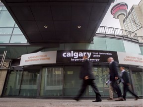 Men walk past the Telus Convention Centre in downtown Calgary in this file photo.