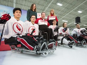 Todd Nicholson, Canada's chef de mission at the Pyeongchang Paralympics, poses for a photo with Canadian Paralympic Committee CEO Karen O'Neill, swimmer Aurelie Rivard and members of the men's para ice hockey team on Jan. 24, 2017.