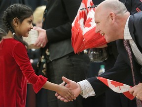 Azka Raza, 7, from Pakistan, receives her Canadian Citizenship from Matt Fell, principal of H.D. Cartwright school during a ceremony at the school in Calgary on Thursday March 15, 2018. Leah Hennel/Postmedia