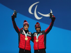 Gold medalists Brian McKeever and his guide Graham Nishikawa of Canada celebrate during the victory ceremony for the Men's 20km free, visually impaired cross-country skiing during day three of the PyeongChang 2018 Paralympic Games on March 12, 2018 in Pyeongchang-gun, South Korea. (Photo by Naomi Baker/Getty Images)