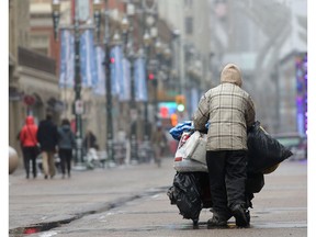 A homeless man who said his name was Jim pushes his shopping cart on the Stephen Avenue Mall of downtown Calgary Friday February 12, 2016. (Ted Rhodes/Postmedia)

0502 ed robson