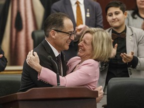 Minister of Finance Joe Ceci and Premier Rachel Notley hug after delivering the budget in Edmonton on March 22, 2018.