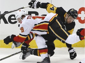 Calgary Flames' Matthew Tkachuk (19) and Pittsburgh Penguins' Tom Kuhnhackl (34) collide in the first period of an NHL hockey game in Pittsburgh, Monday, March 5, 2018.