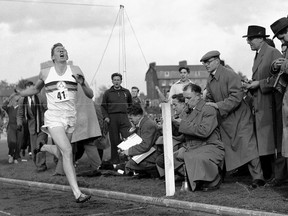 In this May 6, 1954 file photo, Britain's Roger Bannister hits the tape to become the first person to break the four-minute mile in Oxford, England.