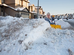 Skyview Ranch resident Tammy Harling's stands behind the massive snow banks that have reduced her street to almost one lane in several places on Monday, March 5, 2018. Harling says the City is not dealing well with snow issues in her neighbourhood despite repeated calls to 311. Gavin Young/Postmedia