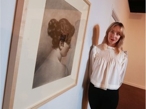 Sarah Todd, curator of new Glenbow Museum exhibit The Artist's Mirror: Self Portraits, stands next to a rare Emily Carr self portrait at the museum.