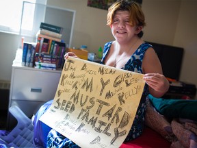 Mustard Seed 1010 Centre resident Jessica McGaughey holds a charcoal drawing with names of fellow residents she calls her "family" in her apartment on Monday March 26, 2018. She says without the affordable housing building she would have been homeless. Gavin Young/Postmedia