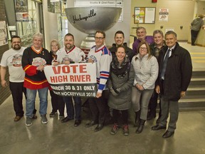 Sylvan Lake Mayor Sean McIntyre, centre left, poses with High River Mayor Craig Snodgrass, centre right, as he presents Snodgrass and High River with the town's mock-up of the Kraft Hockeyville Cup on Thursday, March 29, 2018. High River is one of the final four contestants for the 2018 Kraft Hockeyville contest. (Zach Laing / Postmedia Network)