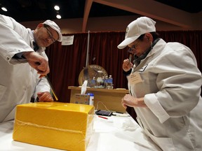 Judges Lars Johannes Nielsen and Kerry Kaylegian inspect a cheddar, aged one to two years, during the World Championship Cheese Contest, Tuesday, March 6, 2018, in Madison, Wis. The biennial event started Tuesday and runs through Thursday night. Organizers say this year there are a record of more than 3,402 entries, with participation up 15 percent from 2016