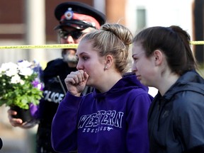 Mackenzie Cooper, 14, left and Cailynn Denoon, 13, are seen outside a home in Ajax, Ont., on Thursday, March 15, 2018, after handing over flowers to a police officer in a show of sympathy for the victims of a triple slaying. Krassimira Pejcinovski, 39, her son Roy Pejcinovski, 15, and daughter Venallia Pejcinovski, 13, all of Ajax, were killed, leading to three second-degree murder charges against 29-year-old Cory Fenn.
