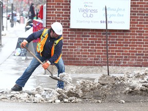 A City of Calgary employee clears a drainage location and pedestrian crossings at 17 Ave and 14 St SW in Calgary Friday, March 9, 2018. Calgary is preparing for warm weather this upcoming week, much to the enjoyment of citizens and have even created a hashtag for the 'event' Jim Wells/Postmedia
