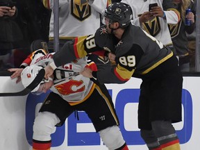 Alex Tuch of the Vegas Golden Knights tangles with Flames defenceman Travis Hamonic on Feb. 21, 2018.