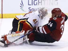 Arizona Coyotes center Zac Rinaldo (34) collides with Calgary Flames goaltender Mike Smith (41) as Rinaldo tries to get off a shot during the second period of an NHL hockey game, Monday, March 19, 2018, in Glendale, Ariz.