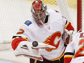 Calgary Flames goaltender Jon Gillies (32) deflects a shot with his stick in the first period of an NHL hockey game against the Pittsburgh Penguins in Pittsburgh, Monday, March 5, 2018.