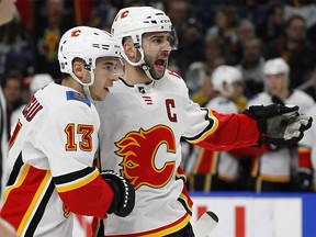 Calgary Flames Johnny Gaudreau (13) and Mark Giordano (5) celebrate a goal during the second period of an NHL hockey game against the Buffalo Sabres, Wednesday, March. 7, 2018, in Buffalo, N.Y. (AP Photo/Jeffrey T. Barnes) ORG XMIT: NYJB106