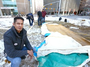 Garret Smith, camp creator, poses as friends work to rebuild a camp in downtown Calgary on Sunday, March 11, 2018 across the street from the Calgary Courts Centre.