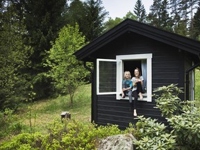 Girls sitting in window of shack