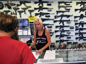 A gun store employee helps a customer at Dragonman's, east of Colorado Springs, Colo., on July 20, 2014.