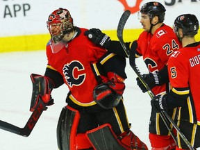 Calgary Flames goaltender Mike Smith celebrates with teammates Travis Hamonic and Mark Giordano after a victory over the Edmonton Oilers during NHL hockey at the Scotiabank Saddledome in Calgary on Tuesday, March 13, 2018. Al Charest/Postmedia