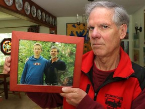 Michael Hornburg holds a photo of him and his son Nathan at his home in Calgary, Alta., on Saturday June 14, 2014. Michael passed away on March 24th, 2018.