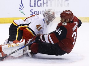 Arizona Coyotes center Zac Rinaldo (34) collides with Calgary Flames goaltender Mike Smith (41) as Rinaldo tries to get off a shot during the second period of an NHL hockey game, Monday, March 19, 2018, in Glendale, Ariz.