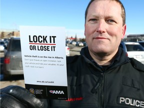 Const. Elliott Lloyd poses with a reminder card at Sunridge Mall on Wednesday, March 7, 2018 as AMA and police launch a campaign to raise awareness of vehicle theft in Alberta.