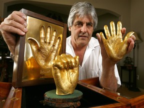Malcolm Duncan with his collection of gold casts of Nelson Mandela's hands.