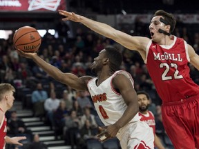 Calgary Dinos' David Kapinga, left, shoots as McGill Redmen's Francois Bourque defends during the first half of semifinal action in the USports men's basketball national championship in Halifax on Saturday, March 10, 2018. THE CANADIAN PRESS/Darren Calabrese ORG XMIT: DBC111